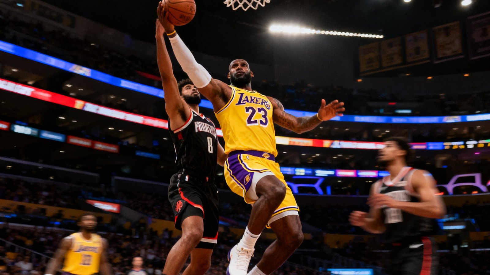 NBA常规赛直播画面，洛杉矶湖人主场斯台普斯中心灯光璀璨，勒布朗·詹姆斯持球突破防守球员向篮筐冲击